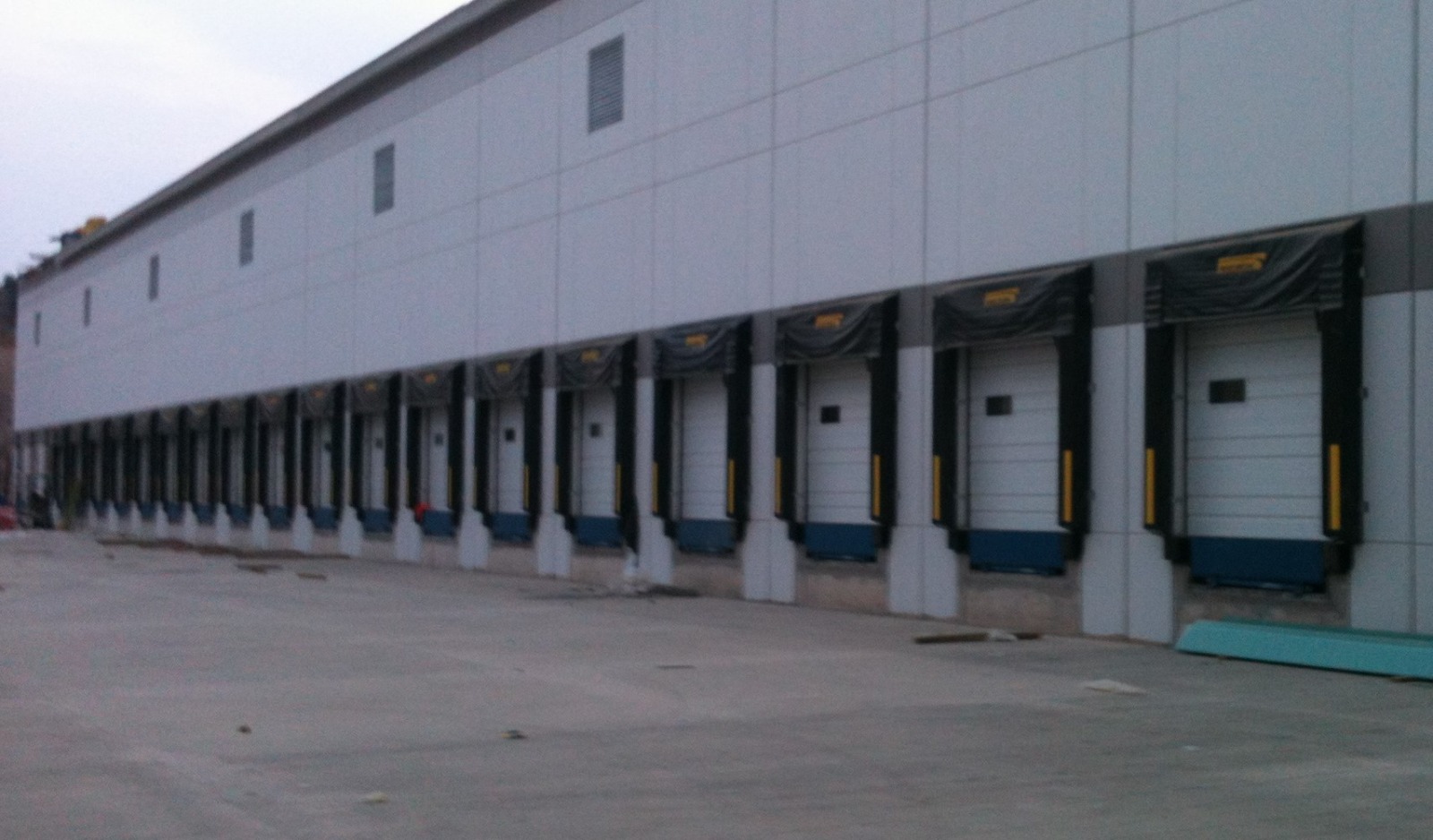 Línea de andenes de carga con abrigos y puertas seccionales en centro de distribución