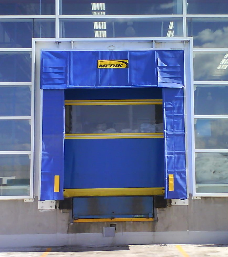 Abrigo de andén azul con rampa niveladora y puerta seccional industrial