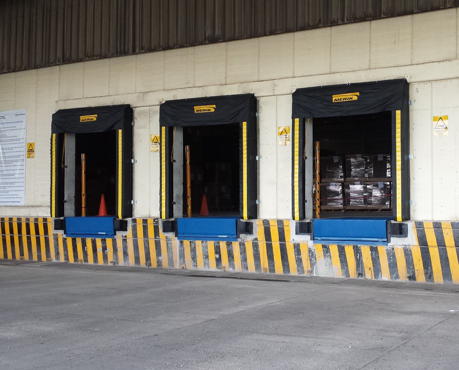 Andenes de carga con puertas automáticas y rampas niveladoras en nave industrial