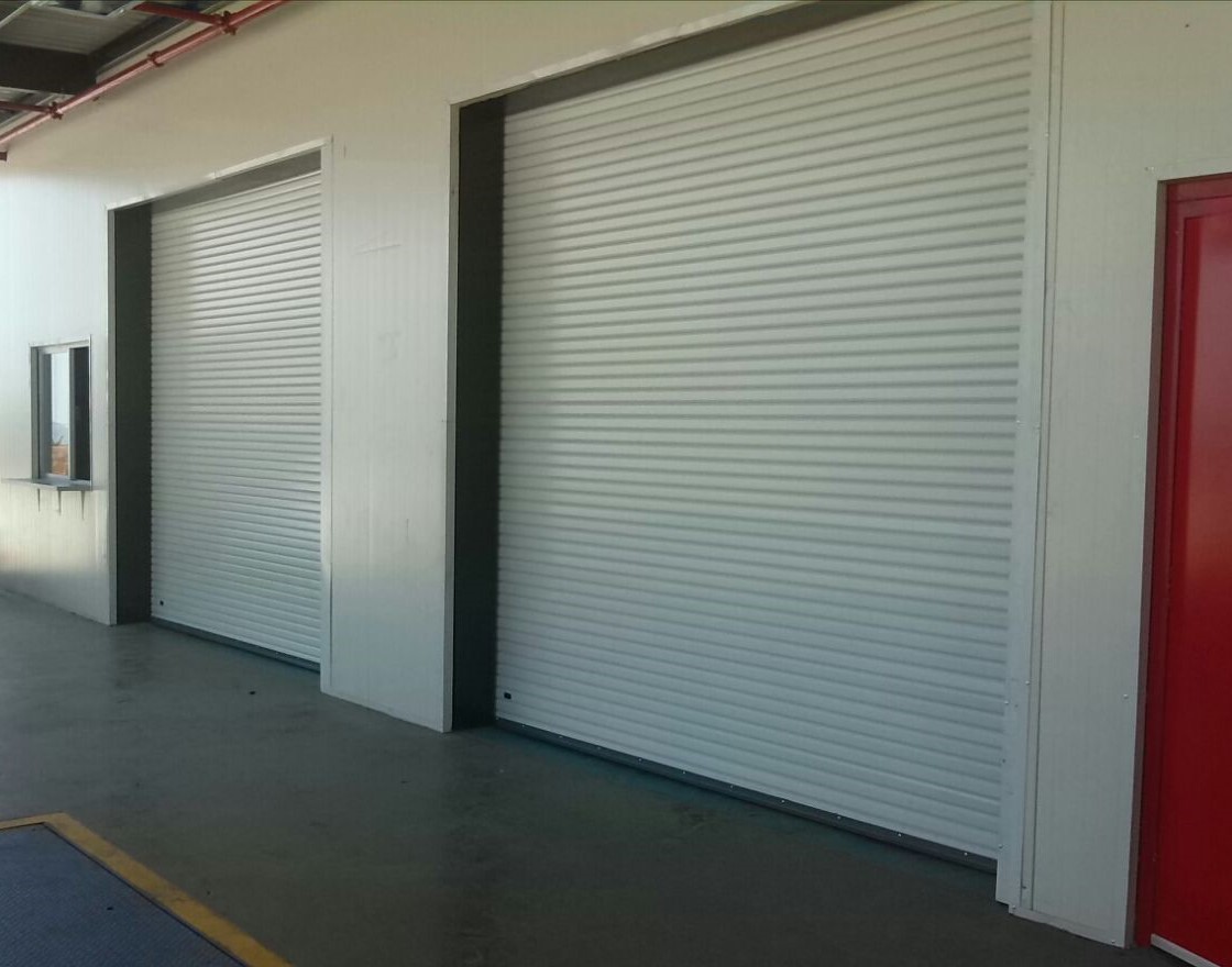Cortinas enrollables blancas instaladas en accesos comerciales
