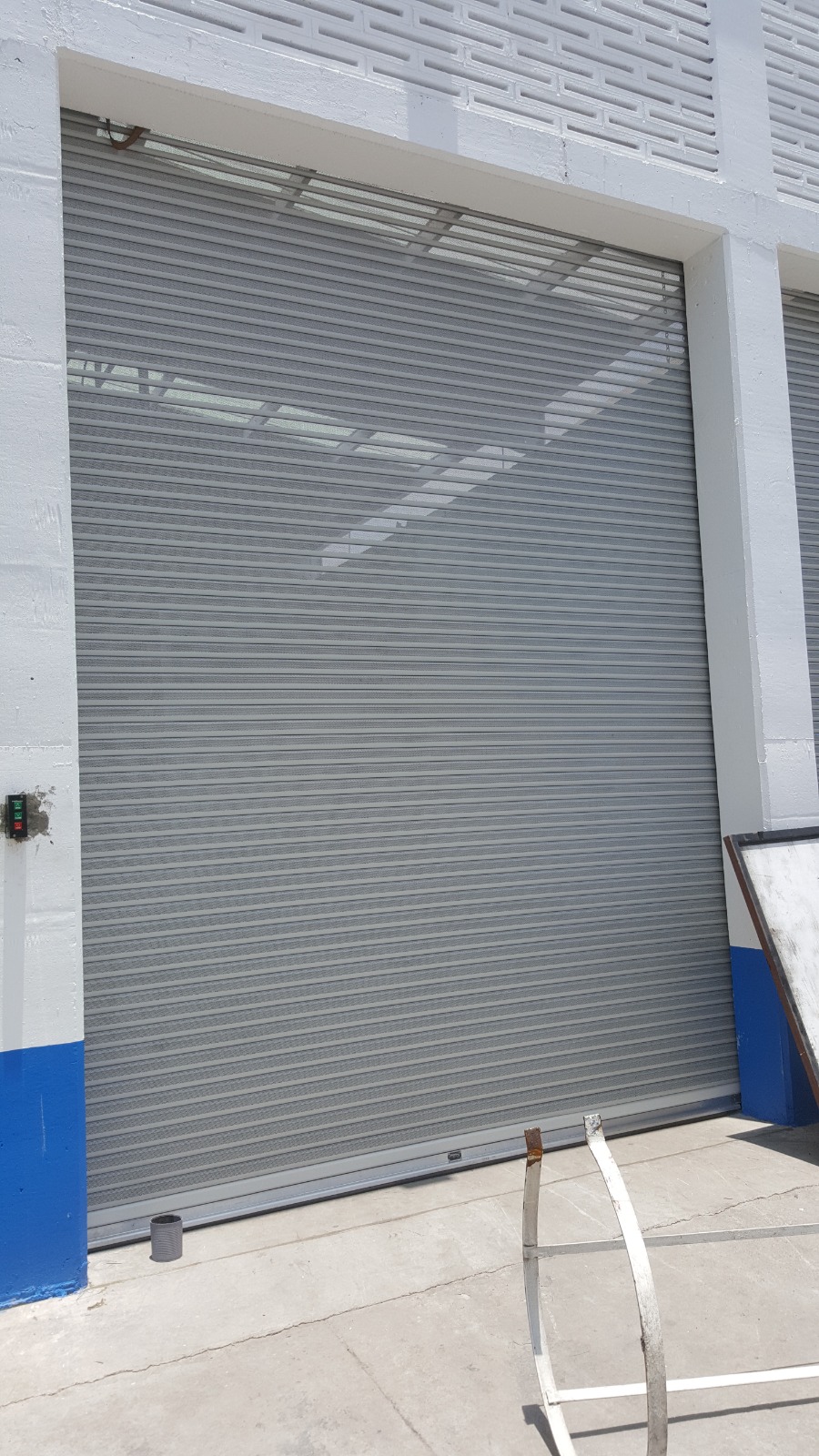 Cortina metálica enrollable automática instalada en acceso de bodega